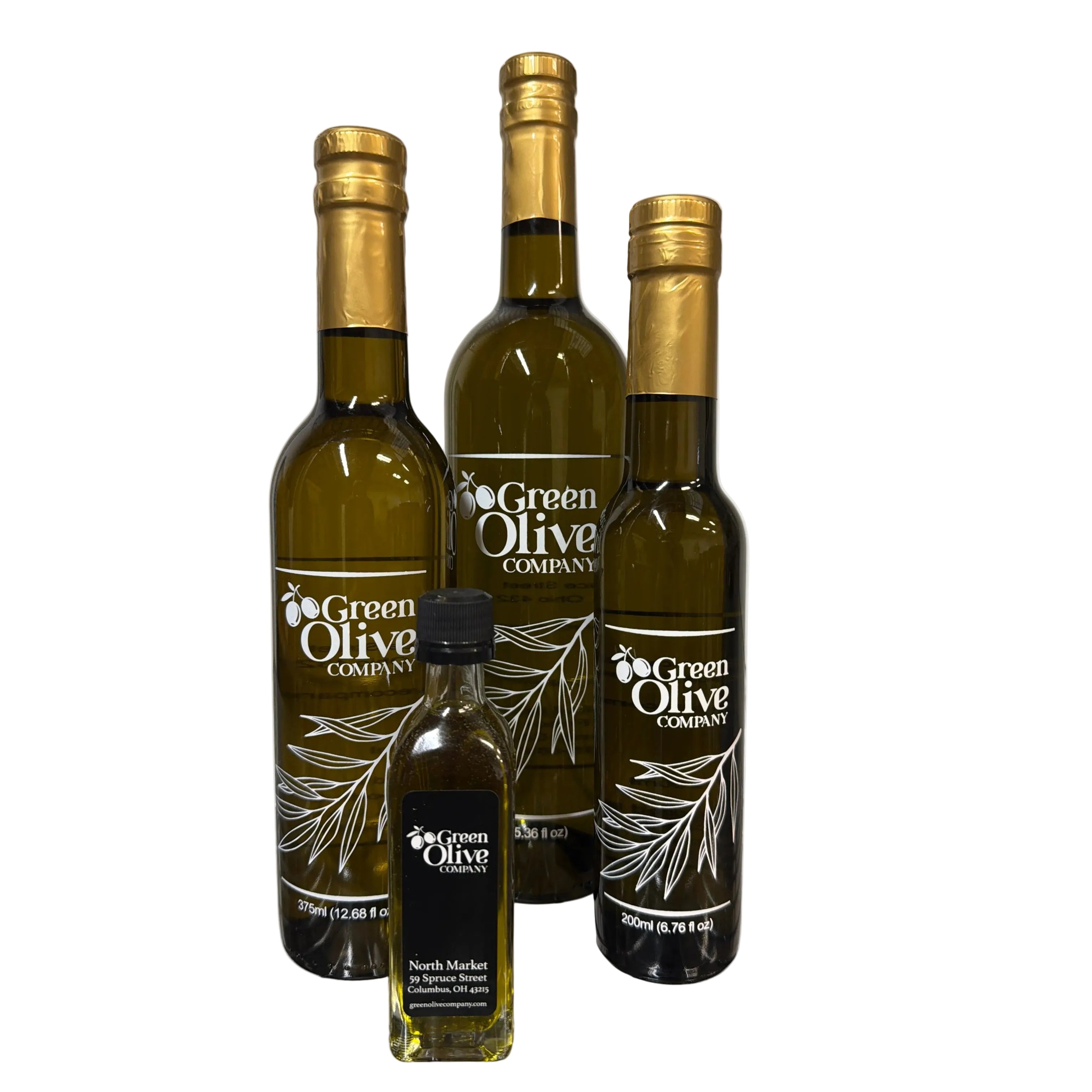 Three bottles of 'Green Olive' olive oil on a metal surface.